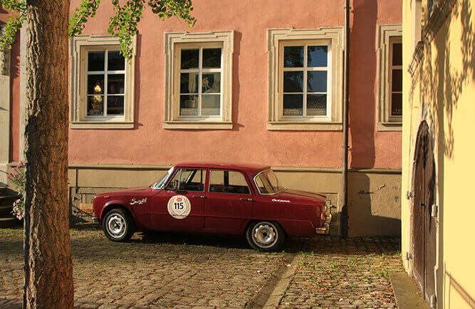 Roter Oldtimer in einem historischen Hof in Bad Mergentheim.