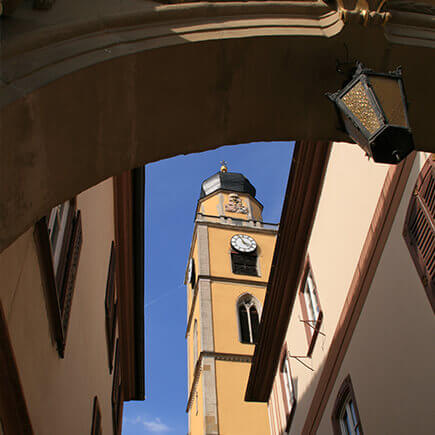 Kirchturm in Bad Mergentheim, aufgenommen aus dem Durchgang zwischen den Zwillingshäusern.