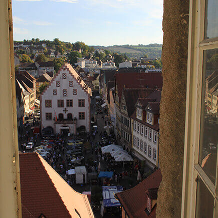 Blick vom Kirchturm auf den Marktplatz in Bad Mergentheim auf dem ein Fest gefeiert wird, im Hintergrund das historische alte Rathaus.