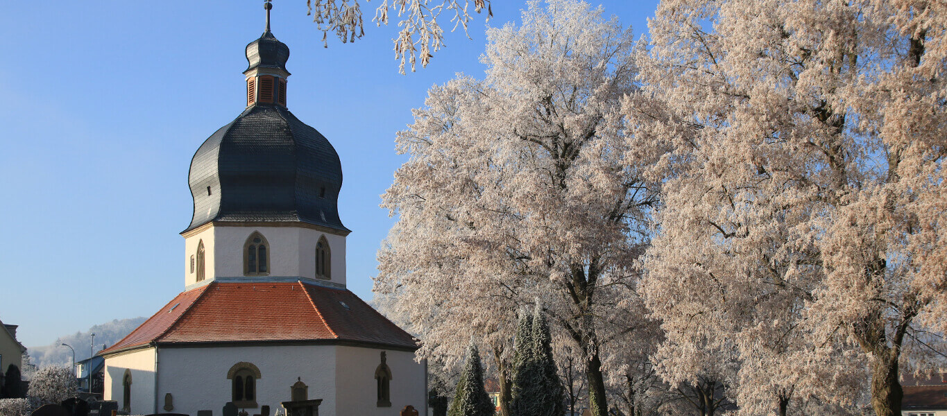 Friedhofskapelle und verschneite Bäume auf dem alten Friedhof in Bad Mergentheim.