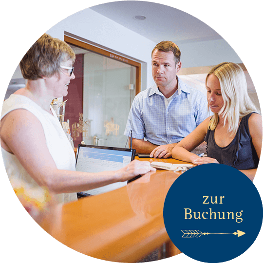 Frau Schulz empfängt an der Rezeption einen Mann und eine Frau als Gäste für ihren Aufenthalt im Hotel Alexa Bad Mergentheim